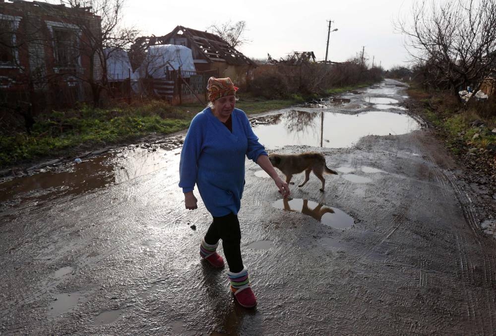 A local resident Lyubov Perepelycya, 65, walks on a street in  Kamyanka village of Kharkiv region on November 25, 2022, amid the Russian invasion of Ukraine. ― AFP pic
