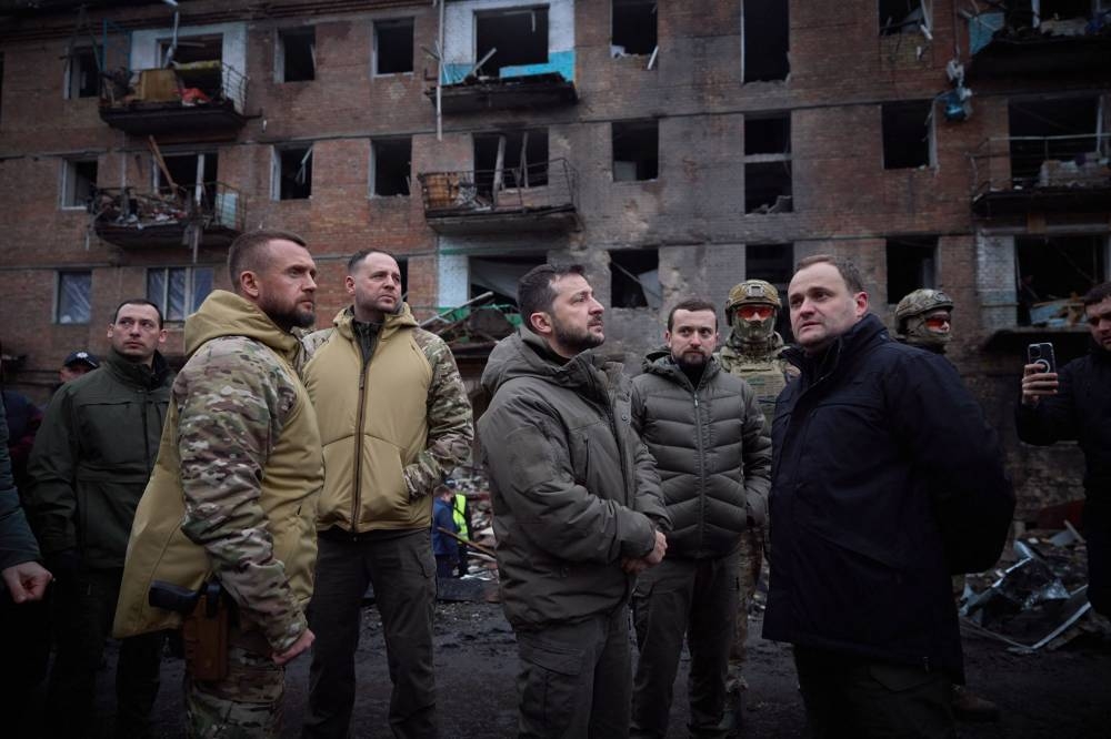 This handout picture taken and released by the Ukrainian Presidential press service on November 25, 2022, shows Ukraine’s President Volodymyr Zelensky (centre) inspecting residential building in Vyshgorod damaged in Russian missile attack, outside of Kyiv, amid the Russian invasion of Ukraine. ― AFP pic