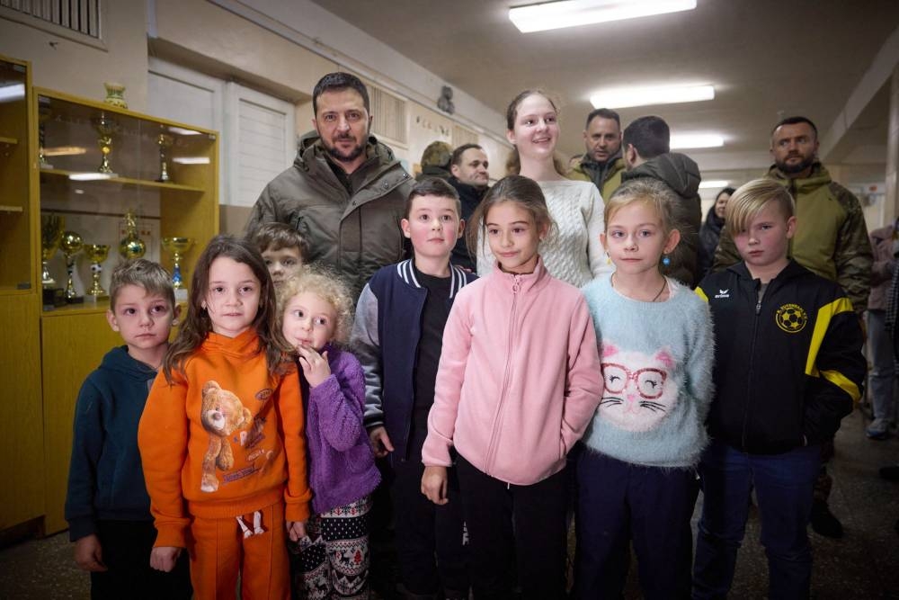 This handout picture released by the Ukrainian Presidential press service on November 25, 2022, shows Ukraine’s President Volodymyr Zelensky poses for a photograph with children as he visits a children's corner in the stationary Point of Invincibility in Vyshgorod, outside of Kyiv, amid the Russian invasion of Ukraine. ― AFP pic
