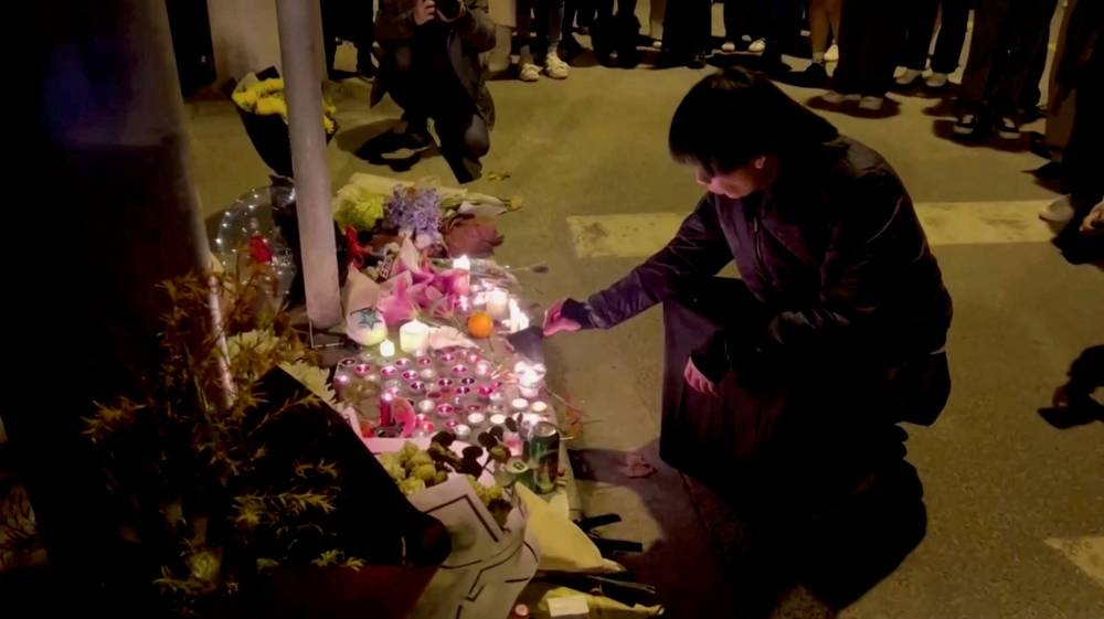 A person lights a candle during a vigil held for the victims of the Urumqi fire, in Shanghai November 26, 2022 in this picture obtained from a social media video. — Gao Ming pic via Reuters