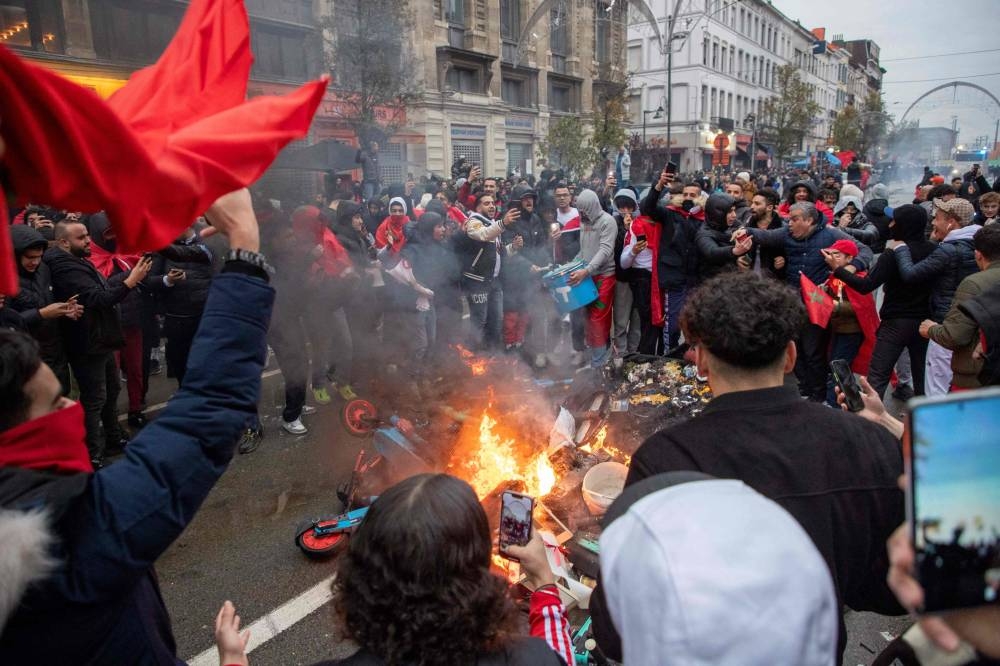 Morroco's supporters celebrate their team's victory after the live broadcast of the Qatar 2022 World Cup Group F football match between Belgium and Morocco, in Brussels, on November 27, 2022. — AFP pic