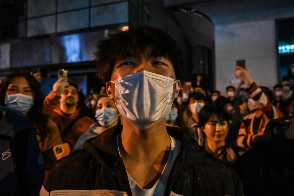 People gather on a street in Shanghai where protests against China's zero-Covid policy took place the night before following a deadly fire in Urumqi, the capital of the Xinjiang region, November 27, 2022. — AFP pic