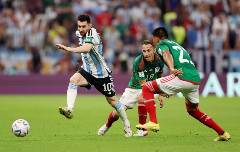  Argentina's Lionel Messi in action with Mexico's Andres Guardado (centre) and Jesus Gallardo at the Lusail Stadium, Lusail November 26, 2022. — Reuters pic