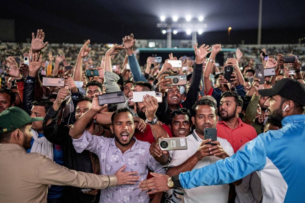 Migrant workers watch the game between Qatar and Ecuador in Doha November 20, 2022. — Reuters pic