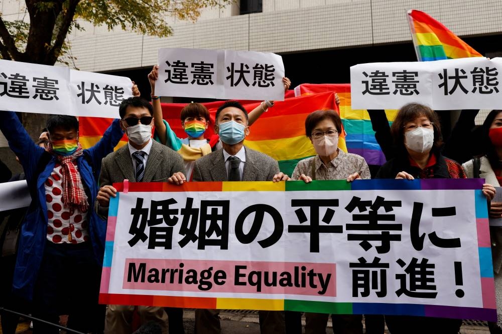 Plaintiffs hold placards outside the court after hearing the ruling on same-sex marriage, in Tokyo November 30, 2022. Placards read ‘A step towards Marriage Equality’ — Reuters pic