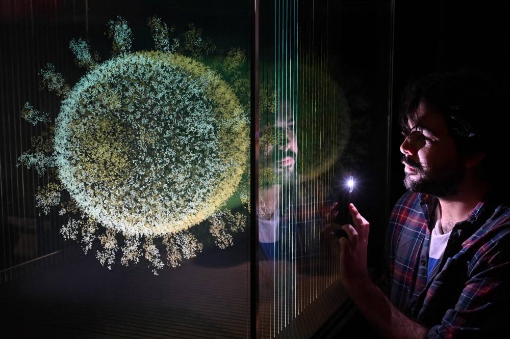 A museum staff member poses with a sculpture entitled 