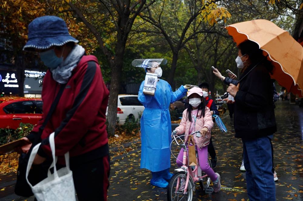 An elderly person scans a QR code at a nucleic acid testing site for Covid-19, in Beijing, China November 11, 2022. — Reuters pic