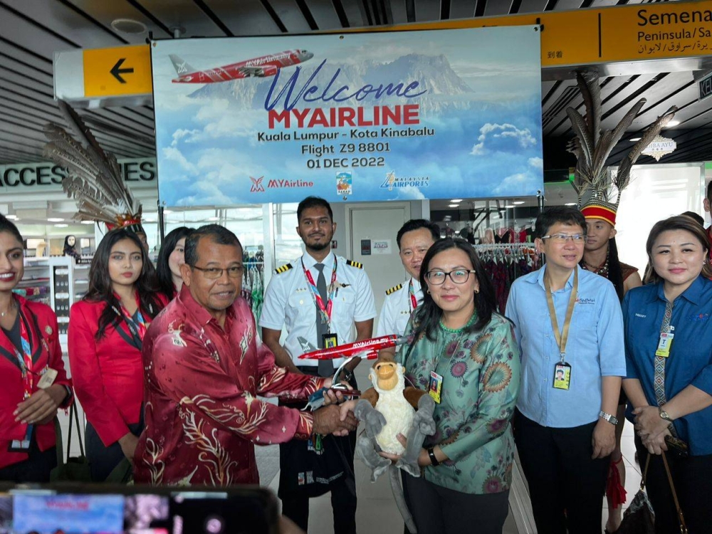 MYAirline director Datuk Abdul Hamid Mohd Ali (left) and Noredah exchanging mementos. ― Borneo Post pic