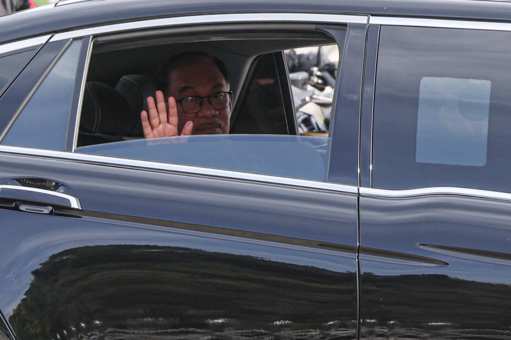 Prime Minister Datuk Seri Anwar Ibrahim waves to the media after his meeting with the Yang di-Pertuan Agong this morning. — Bernama pic