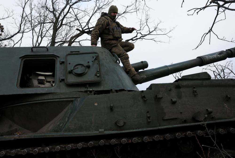 Bogdan, 35, a gunner with the 24th Mechanized Brigade of King Danylo of the Ukrainian Army climbs down from a self propelled artillery vehicle while waiting for coordinates to fire upon a Russian military target as Russia’s invasion on Ukraine continues near Bakhmut in Ukraine, December 3, 2022. — Reuters pic