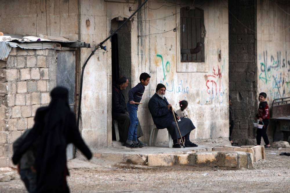 Internally displaced Syrians sit by a road at a camp near a position held by Turkey-backed Syrian fighters in al-Kraydiyeh area, on the frontline with Kurdish-held areas near Syria's northern city of Manbij, close to the border with Turkey, on December 2, 2022. — AFP pic