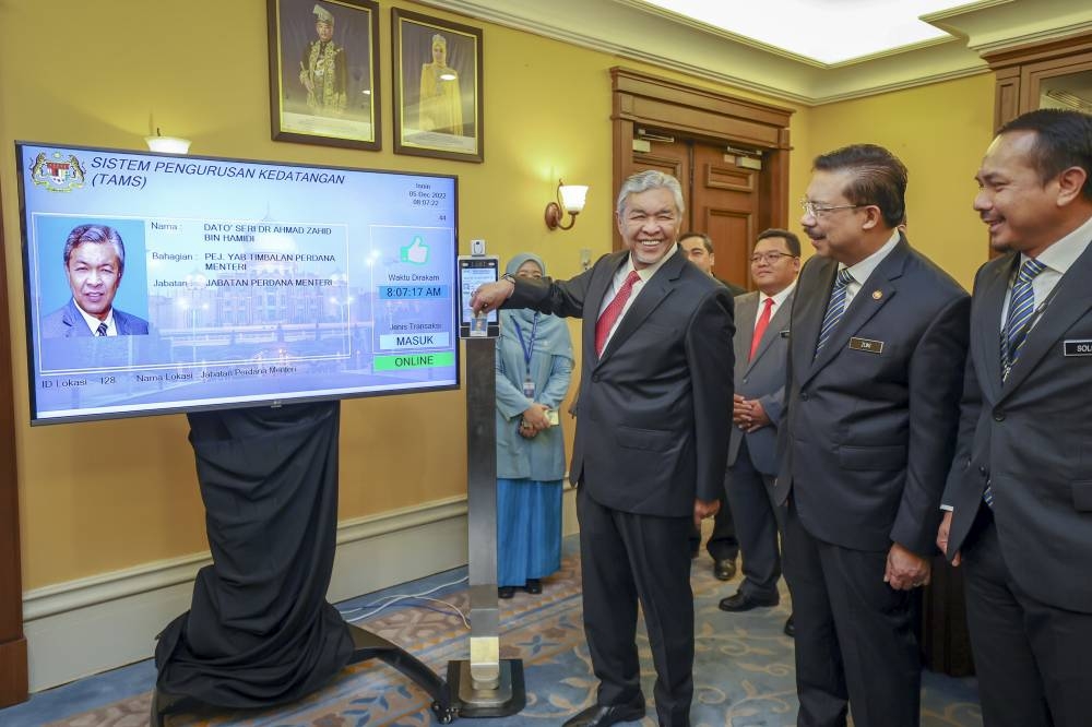 Deputy Prime Minister Datuk Seri Ahmad Zahid Hamidi (centre) clocks in at Perdana Putra in Putrajaya December 5, 2022. — Bernama pic