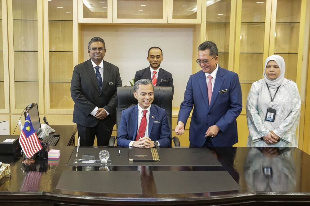 Digital Communications Minister Fahmi Fadzil (seated) poses for a group photo at his office in Putrajaya December 5, 2022. — Picture by Sayuti Zainudin