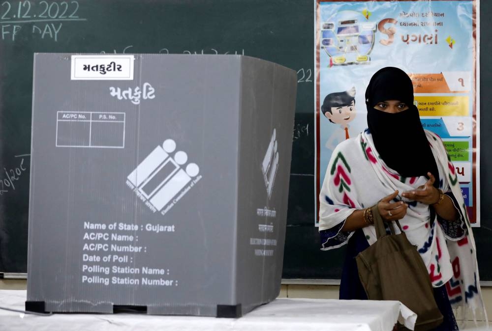 A woman leaves a polling booth after casting her vote during the second and last phase of Gujarat state assembly election in Ahmedabad, India, December 5, 2022. — Reuters pic