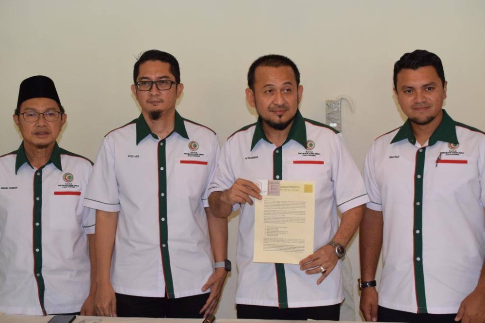 Uzaiman (second right) shows the media statement of the postponement and rearrangement of Sarawak umrah prospects’ flight schedule under the management of Suha.  —  Borneo Post Online pic