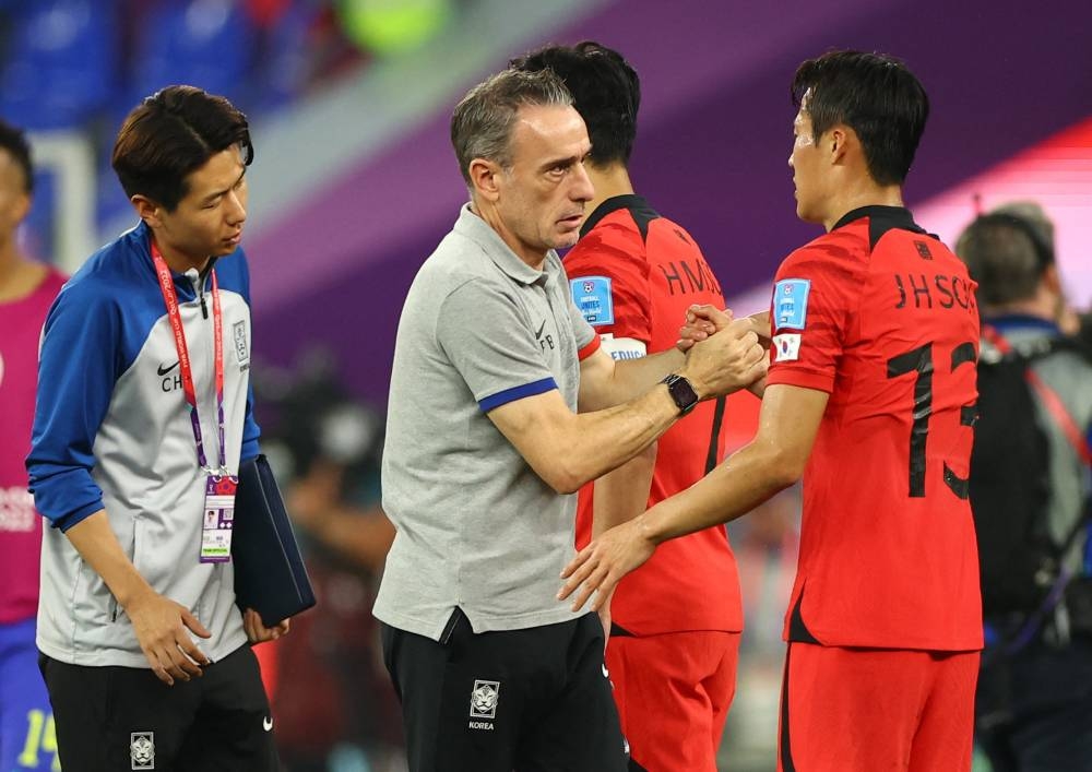 Looking dejected, South Korea coach Paulo Bento shakes hands with Son Jun-ho after the match against Brazil December 5, 2022. ― Reuters pic