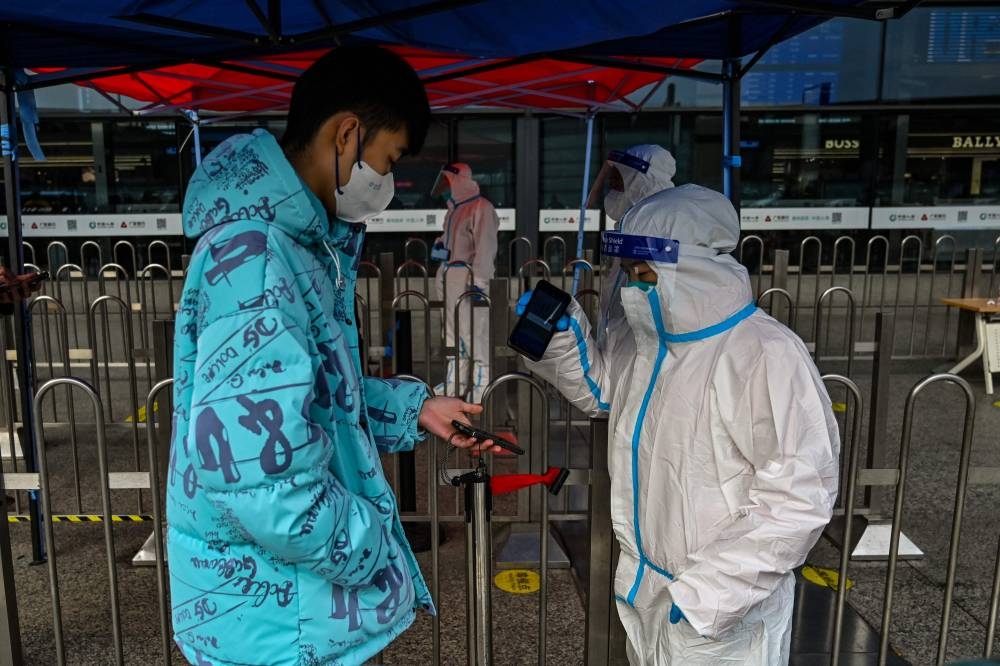 A passenger shows his QR health code at the entrance of the Hongqiao railway station in Shanghai December 5, 2022. ― AFP pic