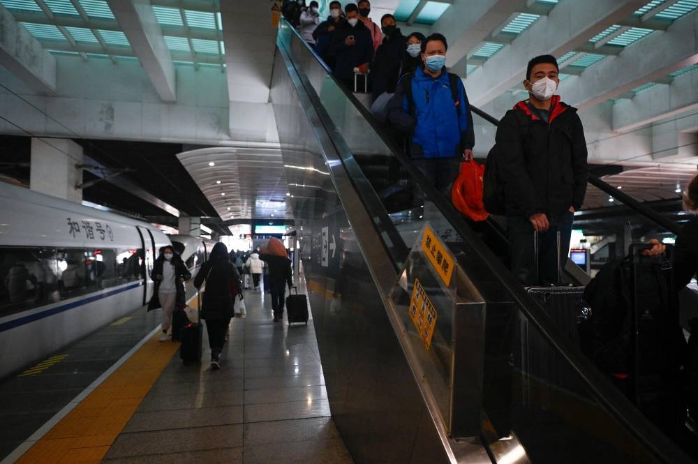 Passengers prepare to board at Beijing south railway station in Beijing on December 8, 2022. — AFP pic