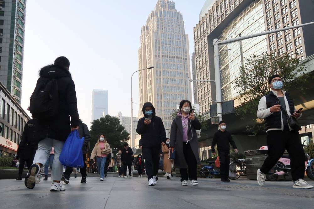 People walk on a street during morning rush hour in Wuchang district, after the government gradually loosened the restrictions on coronavirus disease (COVID-19) control, in Wuhan, Hubei province, China December 9, 2022. — Reuters pic