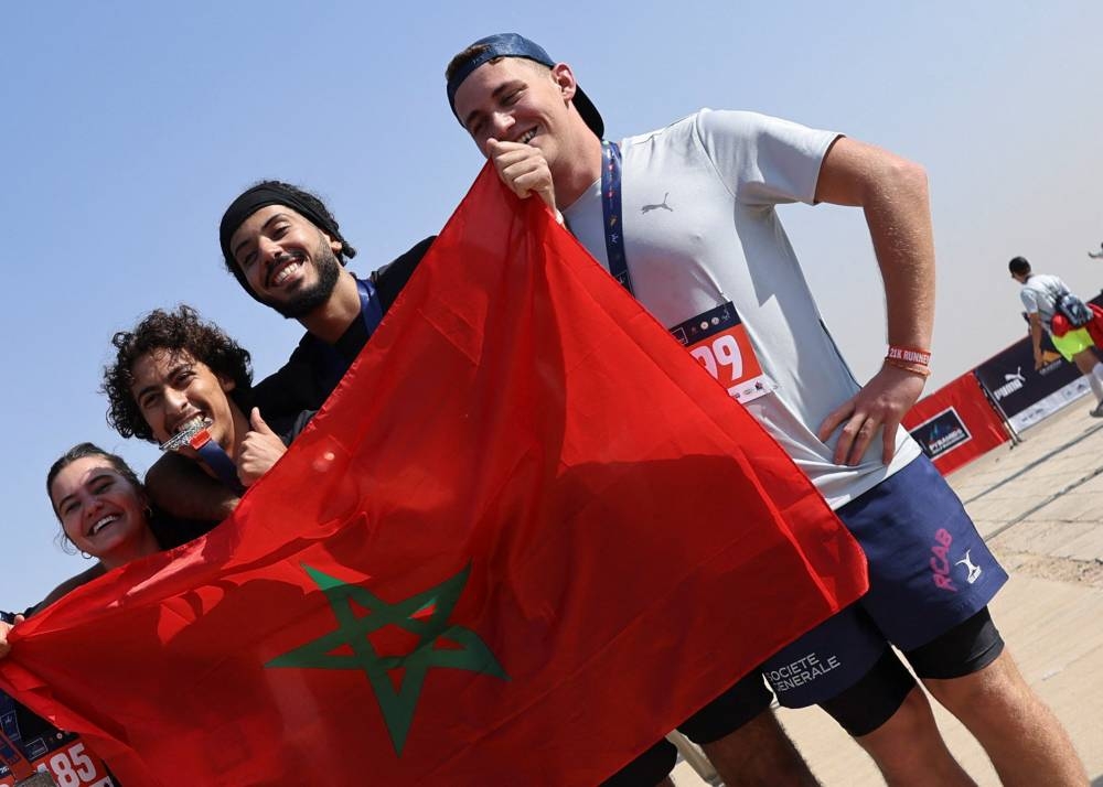 Participants with Morocco flag posse for a picture after finishing the fourth annual Pyramids Half Marathon named ‘Race Through History’ in 2022, in Giza, Egypt December 10, 2022. — Reuters pic
