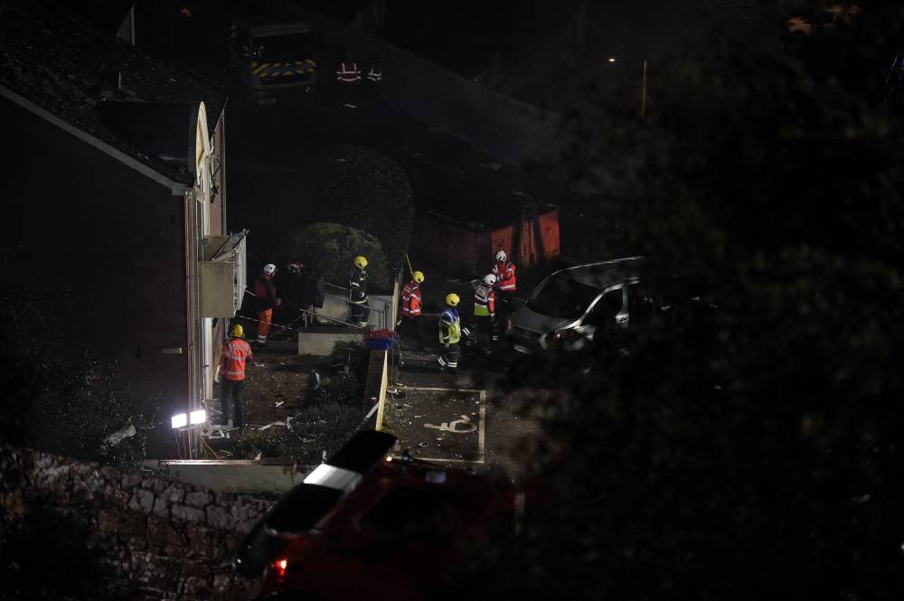 Fire crews mobilised work in the rubble of a low-rise apartment block after an explosion on December 10, 2022 in Saint-Helier, Jersey Island, killed three people and several others are missing, authorities said. — AFP pic