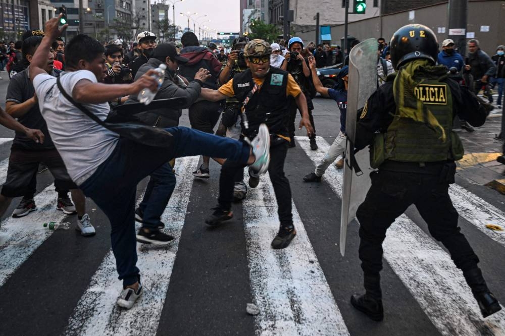 Supporters of Peruvian former President Pedro Castillo clash with riot police during a demonstration demanding his release and the closure of the Peruvian Congress in Lima on December 9, 2022. — AFP pic
