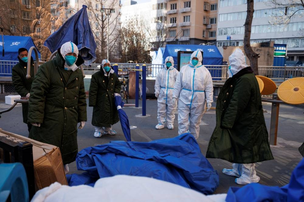Pandemic control workers in protective suits take down tents that served as their living quarters in a neighbourhood that used to be under lockdown, as coronavirus disease (Covid-19) outbreaks continue, in Beijing December 10, 2022. — Reuters pic