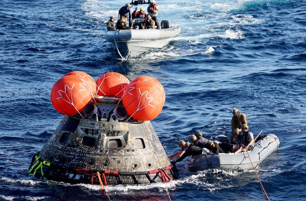 US Navy divers secure Nasa's Orion Capsule during recovery operations after it splashed down following a successful uncrewed Artemis I moon mission on December 11, 2022 seen from aboard the USS Portland in the Pacific Ocean off the coast of Baja California, Mexico.  —Pool pic via Reuters