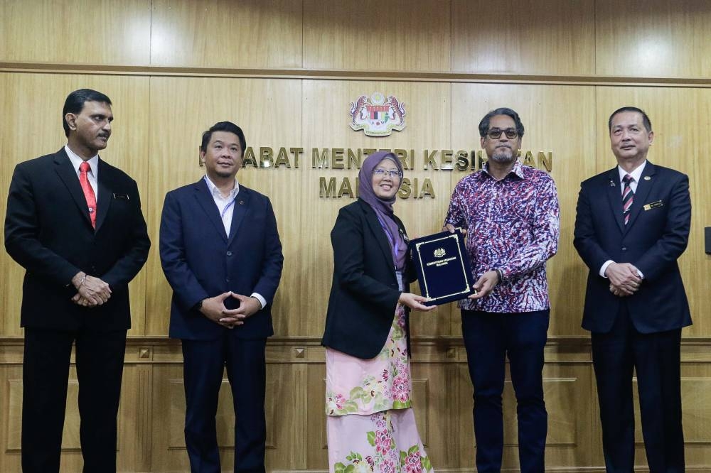 Former health minister Khairy Jamaluddin (second right) and new Health Minister Dr Zaliha Mustafa (centre) during a handover ceremony at the Ministry of Health in Putrajaya December 12, 2022. — Picture by Sayuti Zainudin