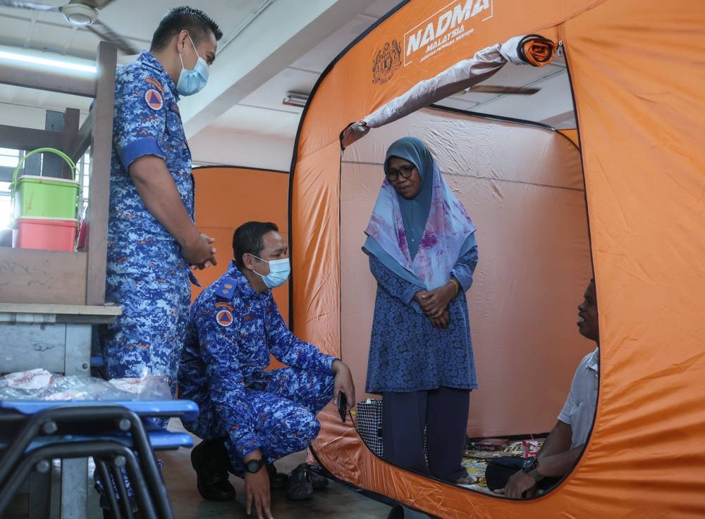 Terengganu Civil Defence Force (APM) director Lieutenant Colonel Mohd Rosman Abdullah (2nd left) speaks to flood victims at a temporary relief centre in SK Tok Jembal in Kuala Nerus December 9, 2022. — Bernama pic