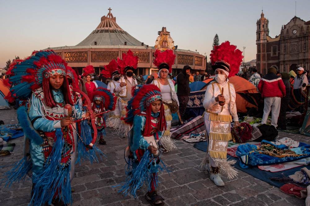 Pilgrims perform a ritual dance at dawn outside the Basilica of Guadalupe in Mexico City on December 12, 2022. — AFP pic