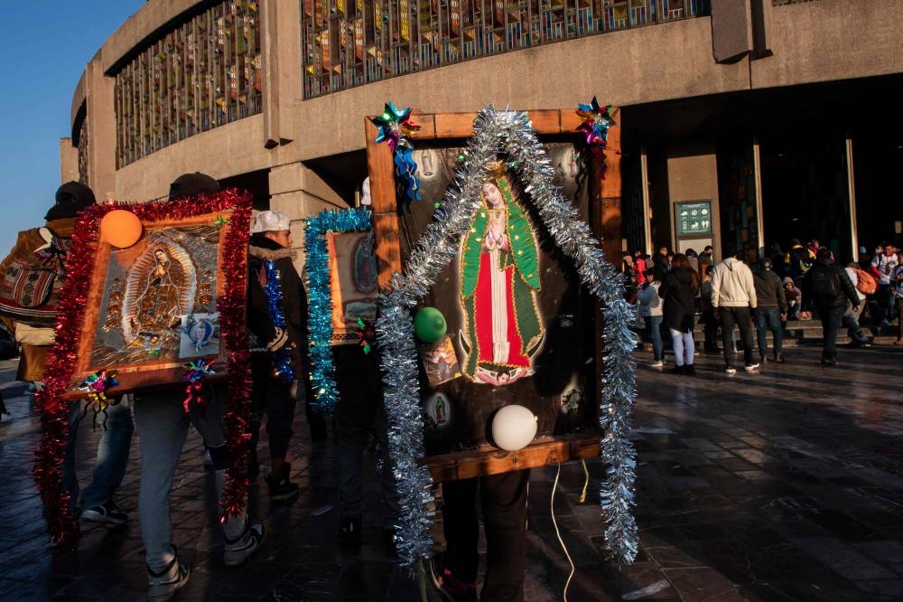 Pilgrims carrying images of the Virgin of Guadalupe enter the Basilica of Guadalupe in Mexico City on December 12, 2022.— AFP pic