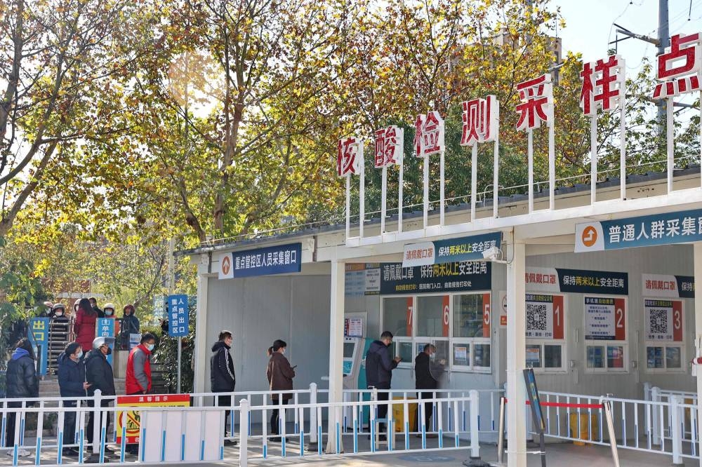 People queue to be tested for Covid-19 coronavirus outside a hospital in Nantong in China's eastern Jiangsu province on December 14, 2022. — AFP pic