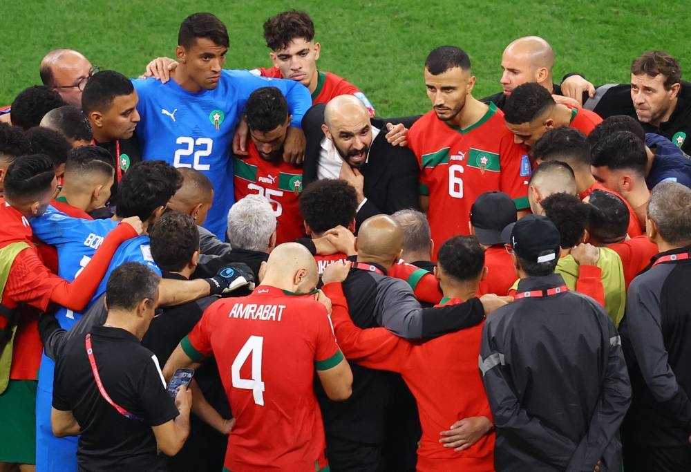Morocco coach Walid Regragui talks with his players after the match against France at the Al Bayt Stadium, Al Khor December 14, 2022. — Reuters pic