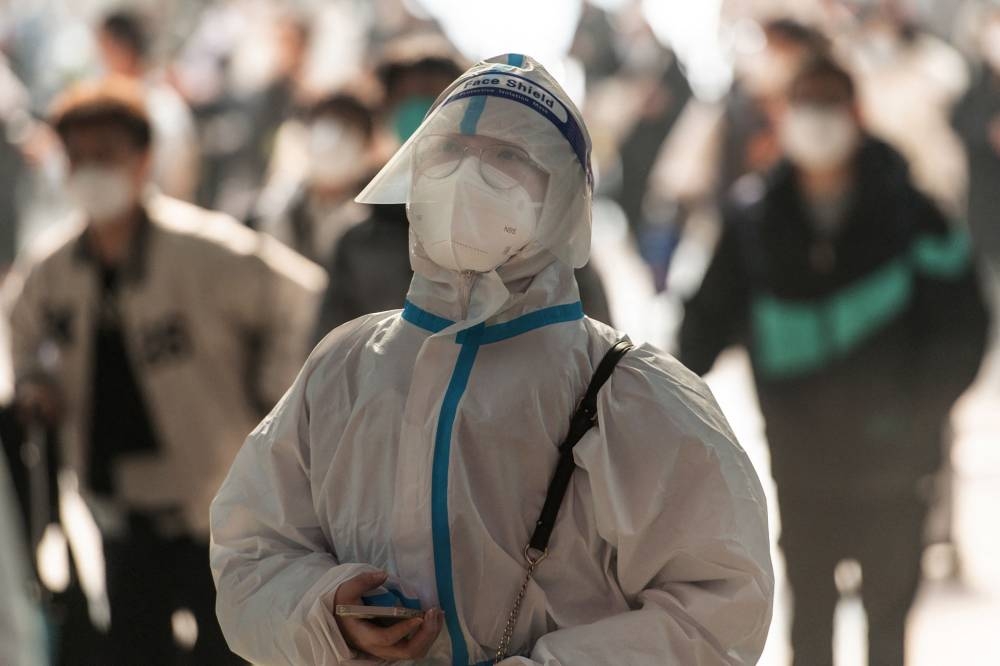 This photo taken on December 10, 2022 shows a passenger wearing personal protective equipment (PPE) amid the Covid-19 pandemic arriving at Hankou Railway Station in Wuhan in China's central Hubei province. — AFP pic