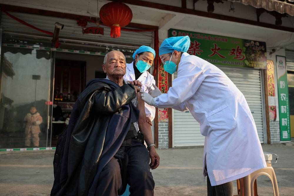 A resident receives a Covid-19 vaccine in Danzhai county, Qiandongnan Miao and Dong Autonomous Prefecture, in China's southwestern Guizhou province on December 12, 2022, as medical workers vaccinate people who can't go out conveniently from their homes. — AFP pic