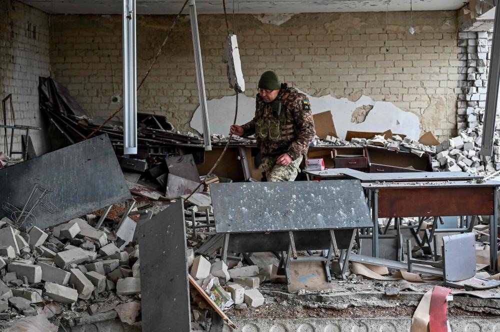 A Ukrainian serviceman inspeacts a room in damaged school building in the liberated village of Petropavlivka near Kupiansk, Kharkiv region on December 15, 2022, amid the Russian invasion of Ukraine. ― AFP pic