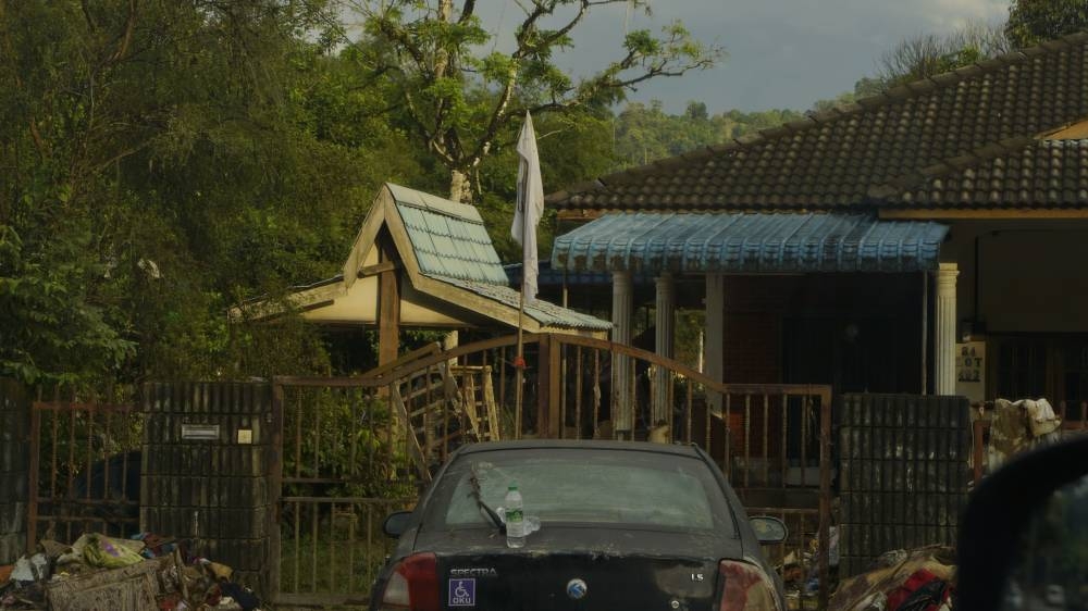 A house in Batu 18, Hulu Langat with a ‘white flag’ hanging outside indicating that someone was trapped inside during the December 18 flood. Picture taken on December 21, 2021. — Picture by Arif Zikri