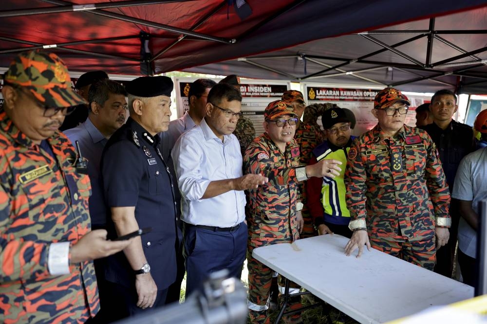 Home Minister Datuk Seri Saifuddin Nasution Ismail being briefed about the landslide that occurred at Father's Organic Farm in Batang Kali early this morning, December 16, 2022. — Bernama pic