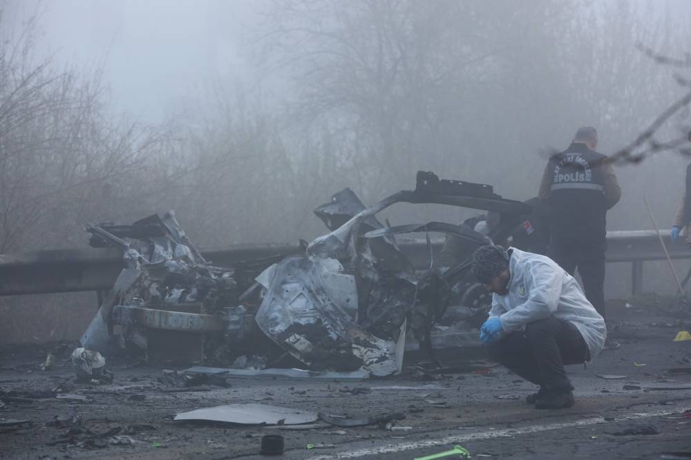 Police forensic experts examine the site after a bomb exploded in a roadside vehicle while a police minibus passed by, in Diyarbakir, Turkey, December 16, 2022. — Reuters pic 