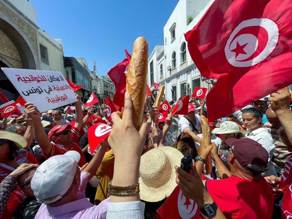 Demonstrators hold loaves of bread as they protest in opposition to a referendum on a new constitution called by President Kais Saied, in Tunis, Tunisia June 18, 2022. — Reuters pic