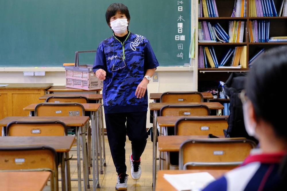 This picture taken on November 22, 2022 shows Masako Shimonomura, a Japanese middle school physical education teacher, talking to a student following a class in Tokyo. — AFP pic