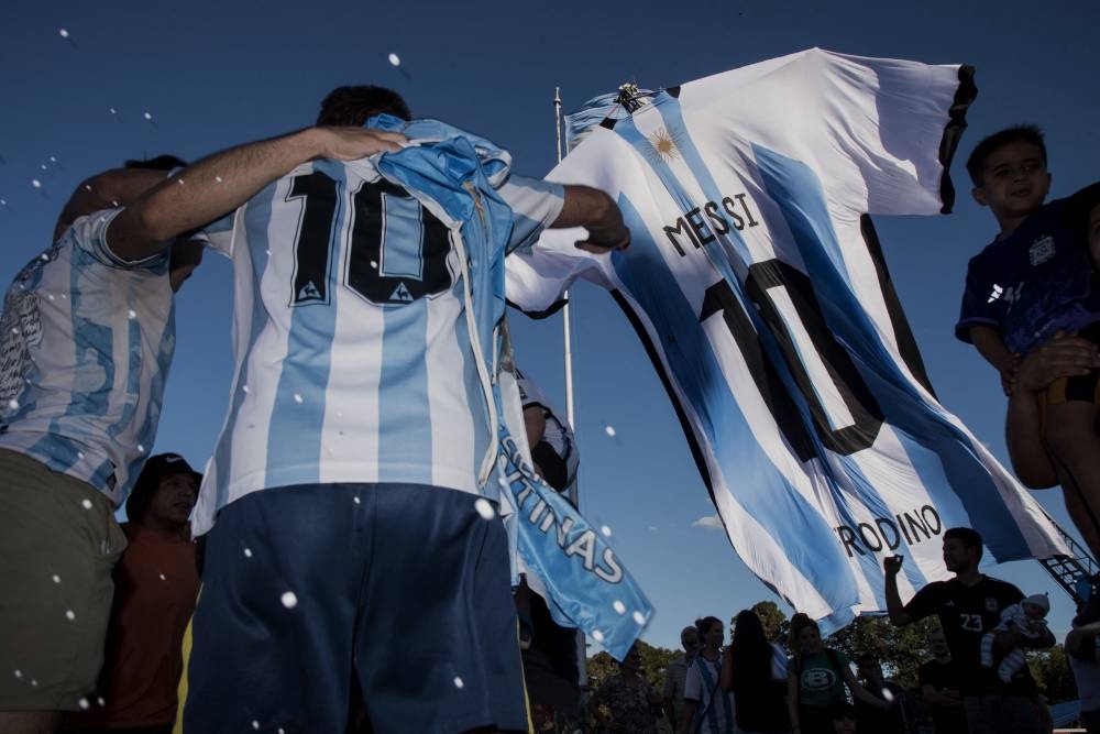 Fans look at a giant jersey of Argentine forward Lionel Messi displayed in Rosario, Argentina, on December 15, 2022, on the eve of the Qatar 2022 World Cup final football match between Argentina and France. — AFP pic