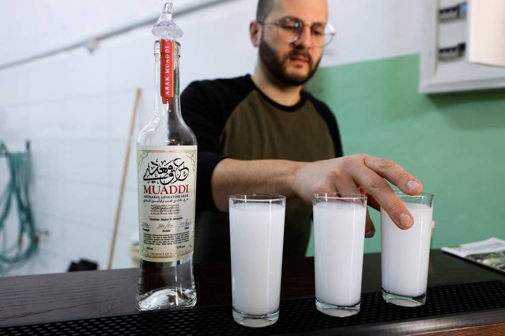 Palestinian Nader Muaddi serves arak at his family distillery in Bethlehem, in the Israeli-occupied West Bank, December 11, 2022. — Reuters pic