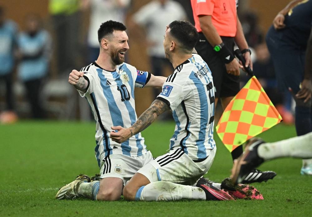 Argentina's Lionel Messi celebrates with Leandro Paredes after beating France to win the Qatar World Cup at the Lusail Stadium December 18, 2022. — Reuters 