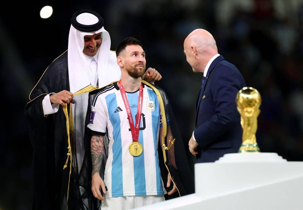 Argentina's Lionel Messi, Emir of Qatar Sheikh Tamim bin Hamad Al Thani and Fifa president Gianni Infantino during the trophy ceremony at the Lusail Stadium December 18, 2022. — Reuters pic