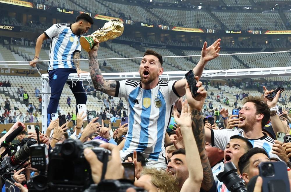 rgentina's Lionel Messi celebrates with the trophy and fans after winning the World Cup at the Lusail Stadium December 18, 2022. — Reuters pic