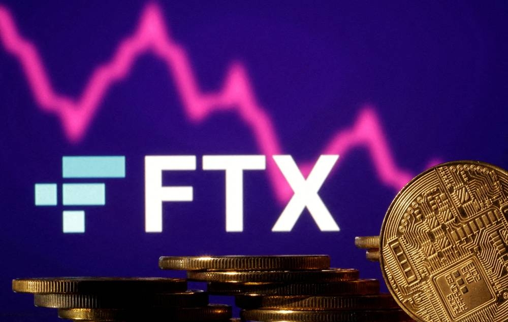 Representations of cryptocurrencies are seen in front of displayed FTX logo and decreasing stock graph in this illustration taken November 10, 2022. — Reuters pic
