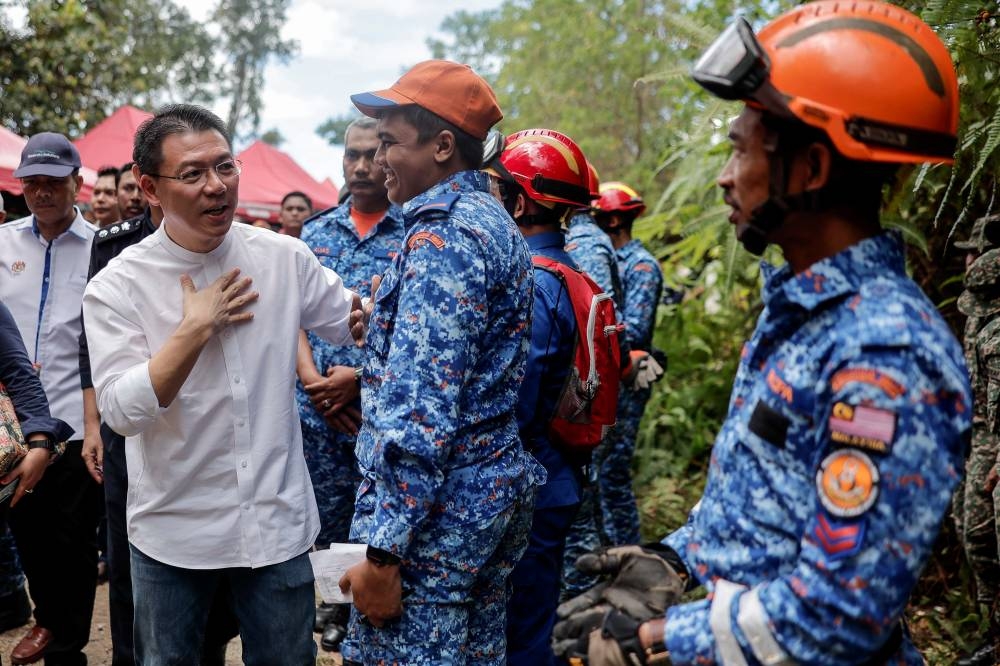Local Government Development Minister Nga Kor Ming speaks to a rescue personnel at the Father's Organic Farm campsite in Batang Kali December 16, 2022. — Bernama pic