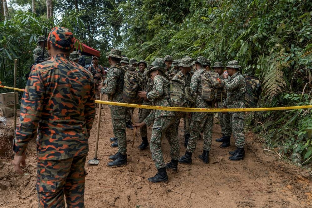 Army personnel getting ready for duty at a nearby stream. — Picture by Shafwan Zaidon